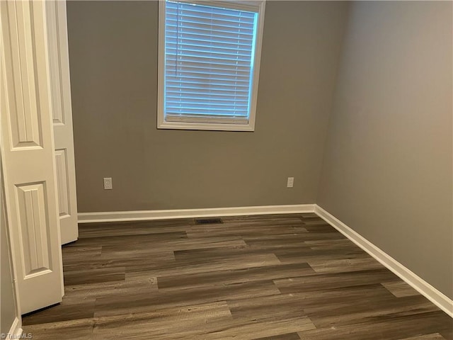 spare room with dark wood-type flooring