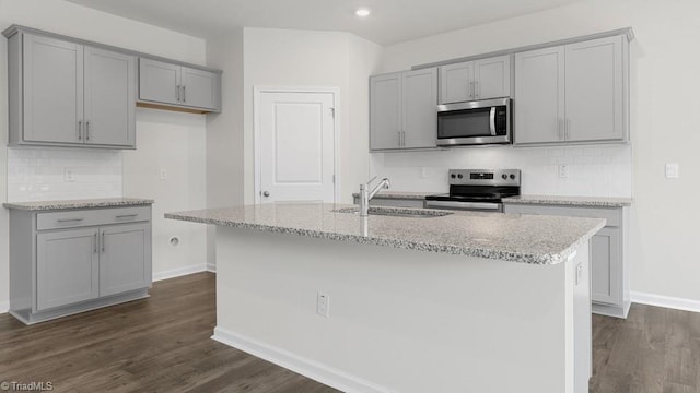 6601 Grogan Hill Rd, Whitsett, NC 27377 - kitchen with appliances with stainless steel finishes, gray cabinets, decorative backsplash, light stone countertops, and recessed lighting