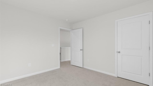 6601 Grogan Hill Rd, Whitsett, NC 27377 - unfurnished bedroom featuring light colored carpet and baseboards