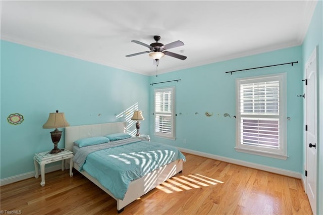 bedroom featuring crown molding, light hardwood / wood-style flooring, and ceiling fan