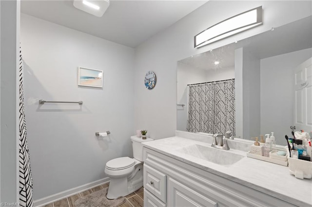 bathroom featuring vanity, toilet, and hardwood / wood-style floors