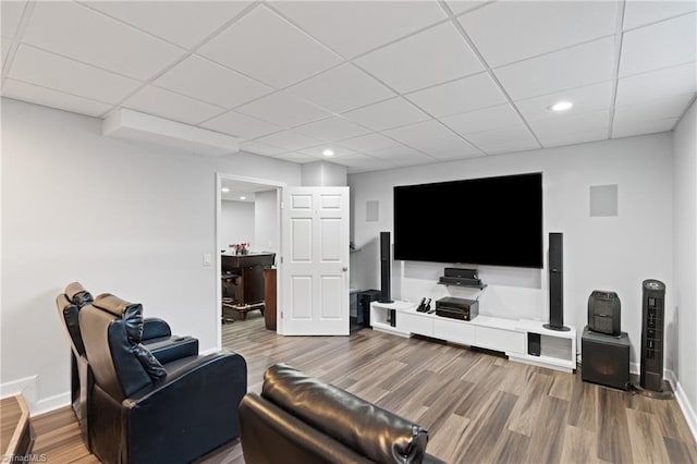 living room with a drop ceiling and wood-type flooring