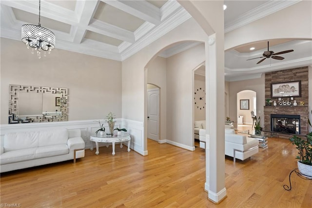 living room with hardwood / wood-style flooring, ornamental molding, beamed ceiling, a fireplace, and coffered ceiling