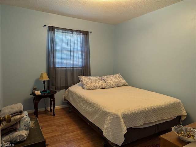 bedroom with wood-type flooring and a textured ceiling