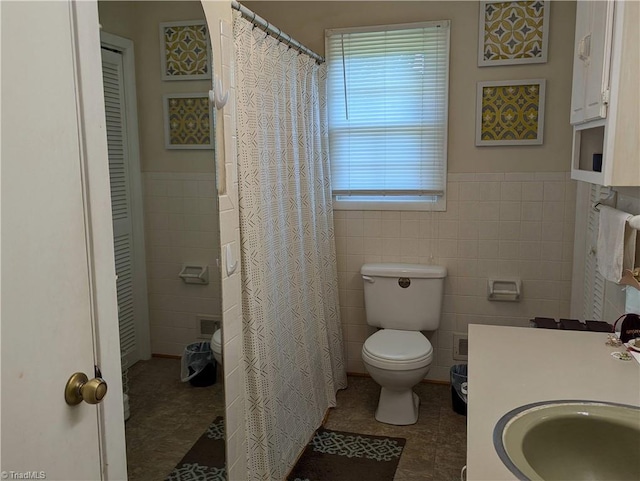 bathroom featuring toilet, tile walls, tile patterned floors, and plenty of natural light