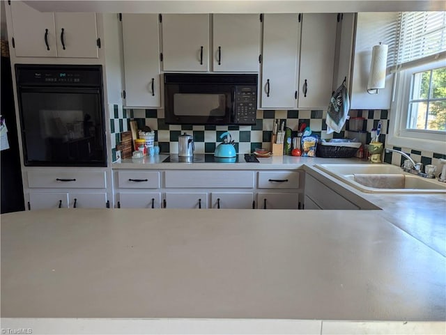 kitchen featuring black appliances, white cabinets, decorative backsplash, and sink