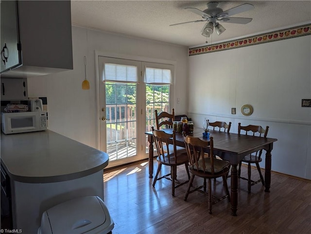 dining space featuring a textured ceiling, ceiling fan, and dark hardwood / wood-style floors