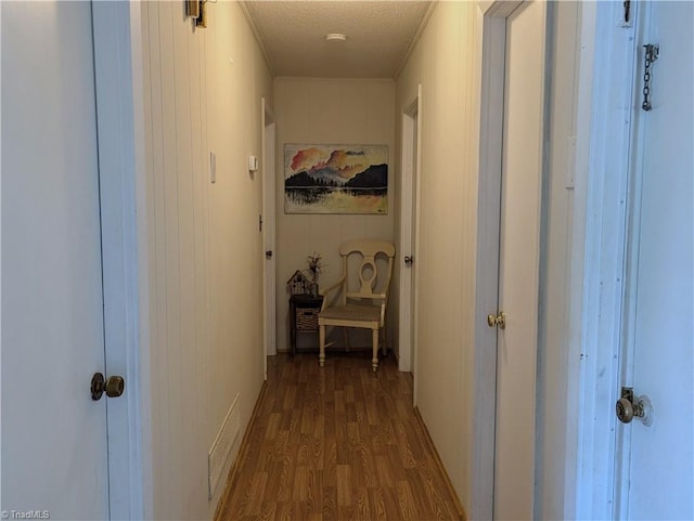 hall with dark wood-type flooring and a textured ceiling