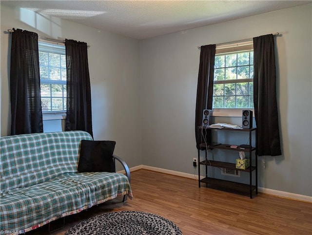 living area featuring hardwood / wood-style flooring and a textured ceiling