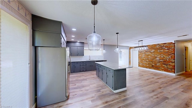 3618 Rockwood Dr, High Point, NC 27265 - kitchen with freestanding refrigerator, a kitchen island, light countertops, a sink, and gray cabinetry