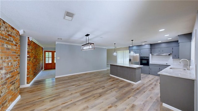 3618 Rockwood Dr, High Point, NC 27265 - kitchen featuring brick wall, visible vents, a sink, stainless steel fridge, and black oven
