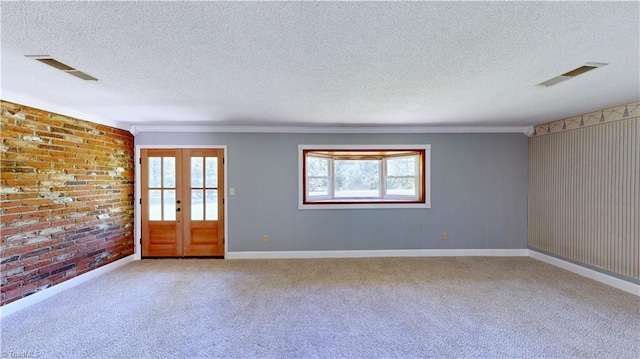 3618 Rockwood Dr, High Point, NC 27265 - unfurnished room featuring a textured ceiling, carpet flooring, ornamental molding, brick wall, and french doors