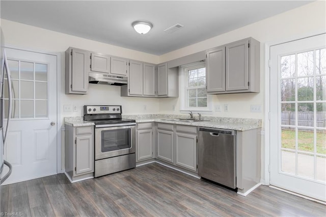 kitchen with appliances with stainless steel finishes, dark hardwood / wood-style floors, gray cabinetry, and sink