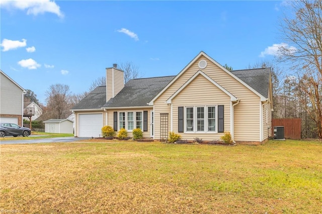 view of front of home featuring central AC unit, a front yard, and a garage