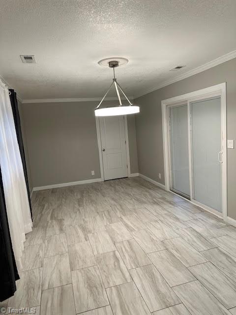 unfurnished room with crown molding, baseboards, a textured ceiling, and visible vents