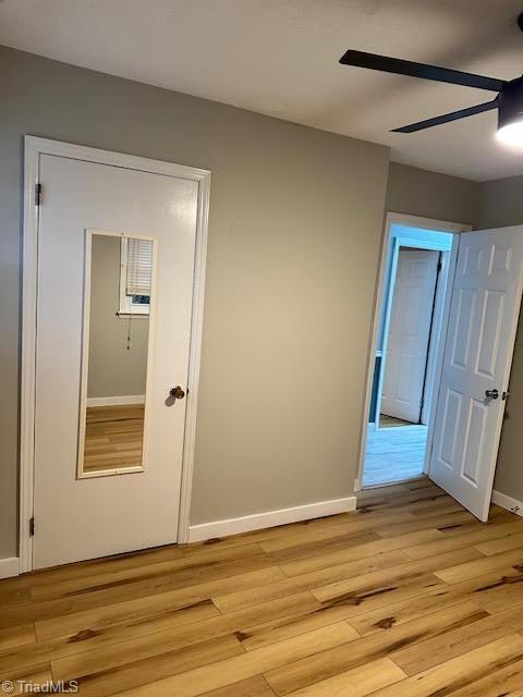 corridor with baseboards and light wood finished floors