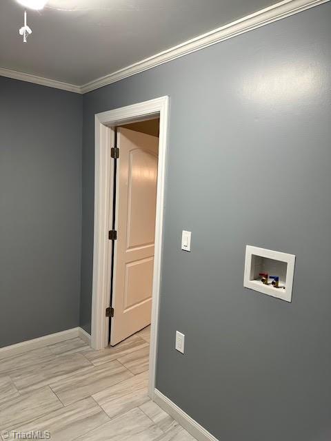 clothes washing area with crown molding, baseboards, washer hookup, and laundry area