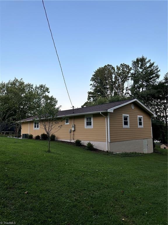view of side of home with a yard