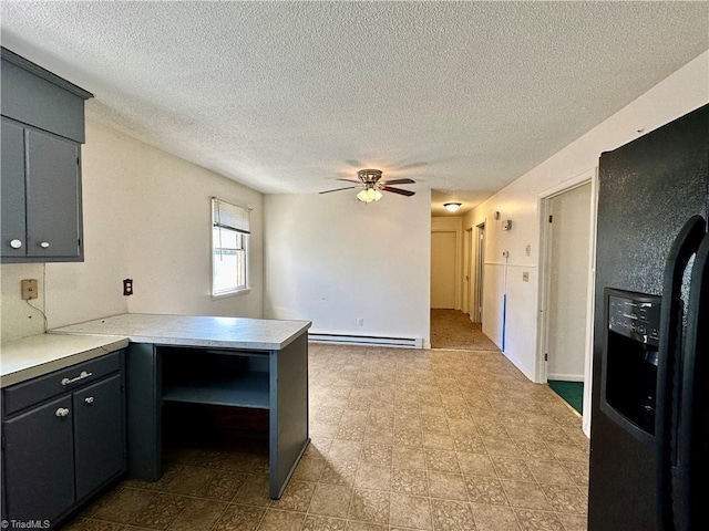 kitchen featuring ceiling fan, a baseboard heating unit, a textured ceiling, black fridge with ice dispenser, and kitchen peninsula