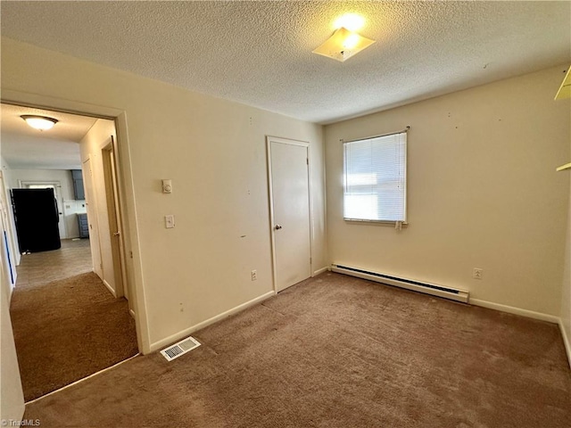 carpeted empty room with a baseboard radiator and a textured ceiling