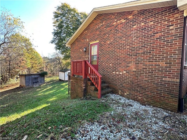 view of side of property with a lawn and a storage unit