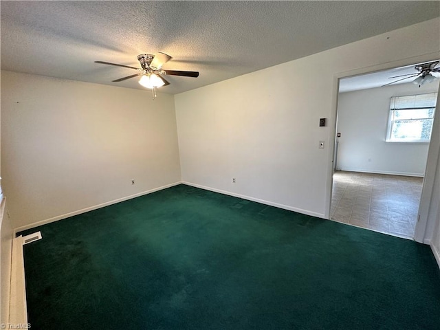 empty room with a textured ceiling, ceiling fan, and dark colored carpet