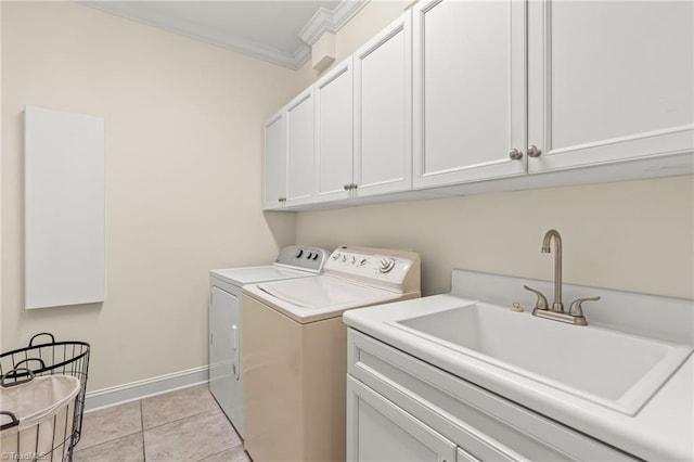 clothes washing area featuring cabinets, crown molding, sink, light tile patterned floors, and washing machine and dryer