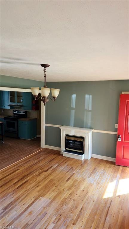 unfurnished living room featuring a chandelier and hardwood / wood-style flooring