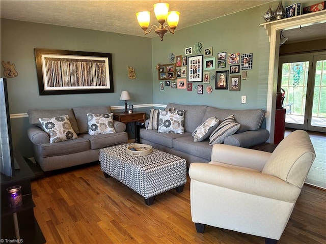 living room featuring a textured ceiling, hardwood / wood-style floors, and a notable chandelier