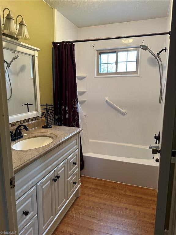 bathroom featuring shower / tub combo, hardwood / wood-style floors, and vanity