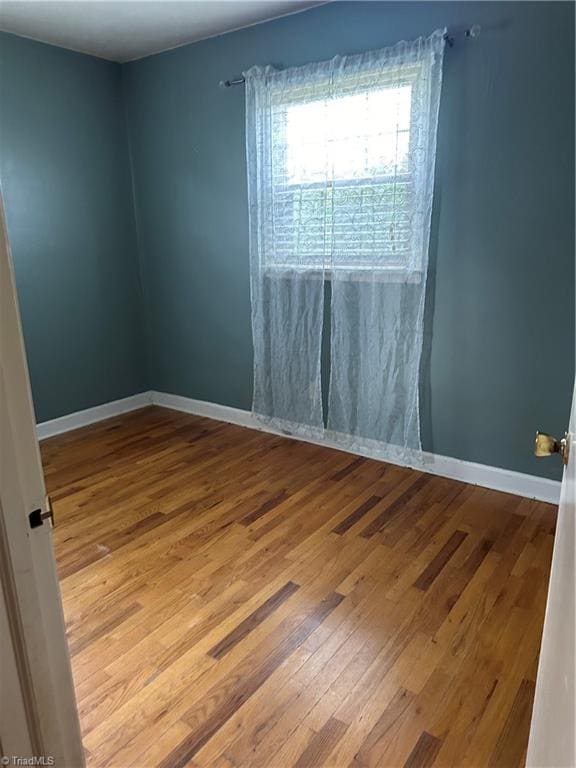 spare room with hardwood / wood-style flooring