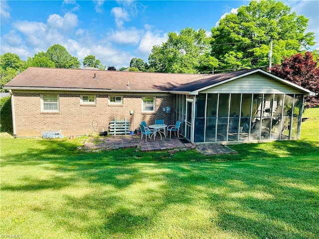 rear view of house featuring a sunroom, a yard, and a patio