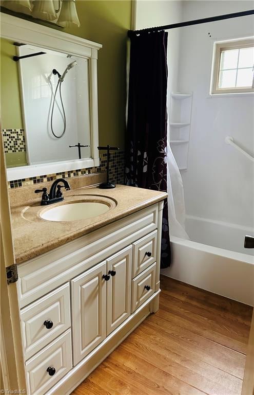 bathroom with vanity, hardwood / wood-style floors, and shower / bathtub combination with curtain