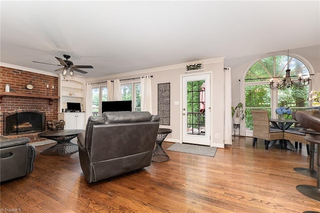 3016 Havasu Way, High Point, NC 27265 - living room featuring wood finished floors, a brick fireplace, a ceiling fan, a chandelier, and plenty of natural light