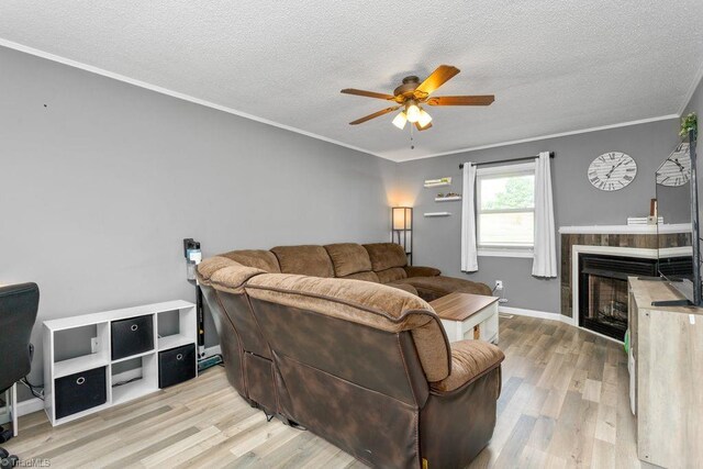 415 Crestview Dr, Thomasville, NC 27360 - living room featuring ceiling fan, wood finished floors, a textured ceiling, crown molding, and a fireplace