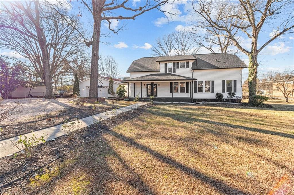 view of front of house with covered porch and a front yard