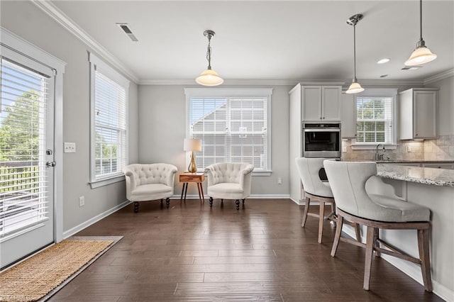 4420 Bonnie Loch Dr, Burlington, NC 27215 - kitchen featuring oven, ornamental molding, light stone counters, baseboards, and a kitchen bar