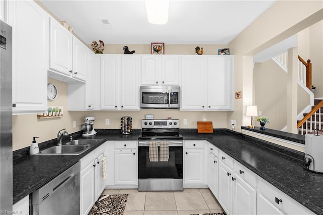 kitchen with stainless steel appliances, a sink, and white cabinets