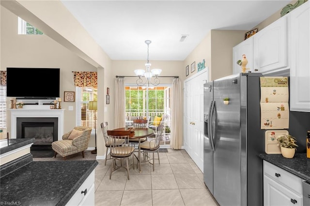 kitchen with stainless steel fridge with ice dispenser, a chandelier, white cabinets, and dark stone countertops