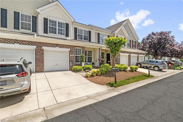 townhome / multi-family property with driveway, a garage, and brick siding