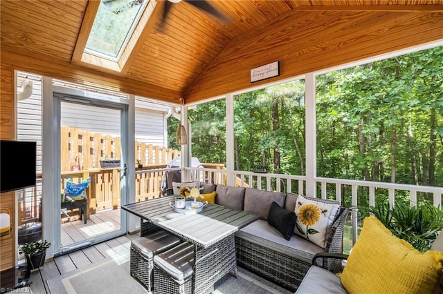 sunroom / solarium featuring lofted ceiling, a skylight, outdoor lounge area, and ceiling fan