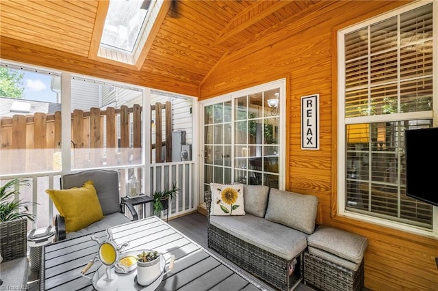 sunroom / solarium featuring vaulted ceiling, outdoor lounge area, and a skylight