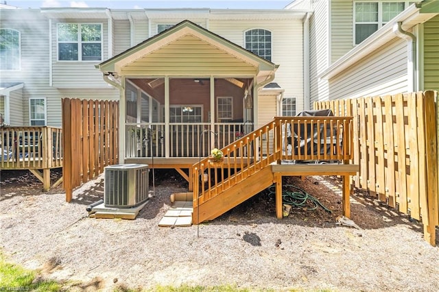 back of house featuring a sunroom, central AC unit, a wooden deck, and fence