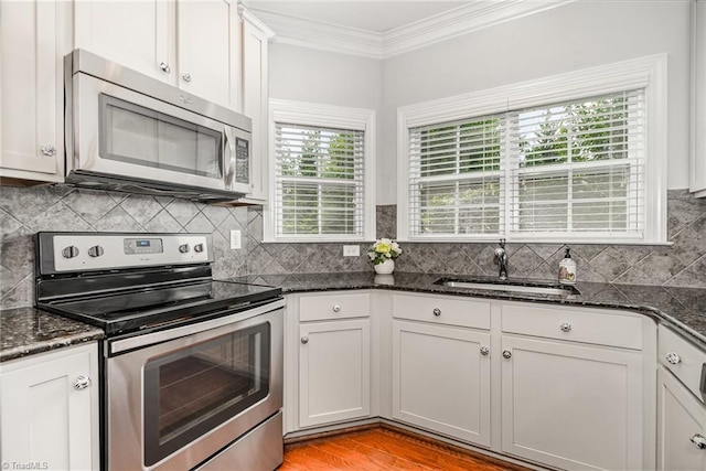 5207 York Place Ct, Walkertown, NC 27051 - kitchen with stainless steel appliances, ornamental molding, dark stone countertops, decorative backsplash, and white cabinets