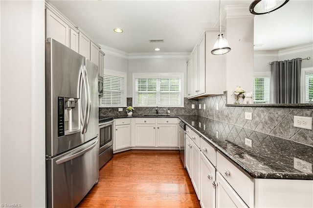 5207 York Place Ct, Walkertown, NC 27051 - kitchen featuring stainless steel appliances, healthy amount of natural light, wood finished floors, dark stone counters, and ornamental molding