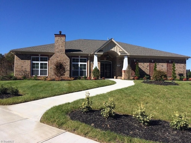 5207 York Place Ct, Walkertown, NC 27051 - view of front of home featuring brick siding, a front yard, a chimney, and roof with shingles