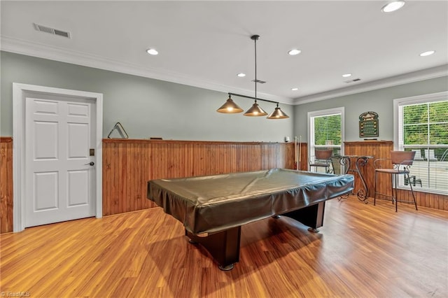 game room with light hardwood / wood-style floors, ornamental molding, pool table, and bar area