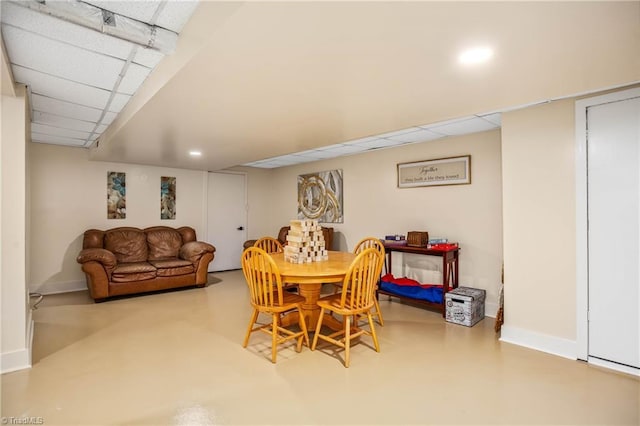 dining area with a drop ceiling, concrete floors, baseboards, and recessed lighting