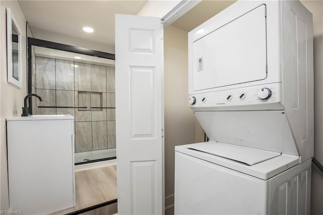 clothes washing area featuring estacked washer and dryer and recessed lighting