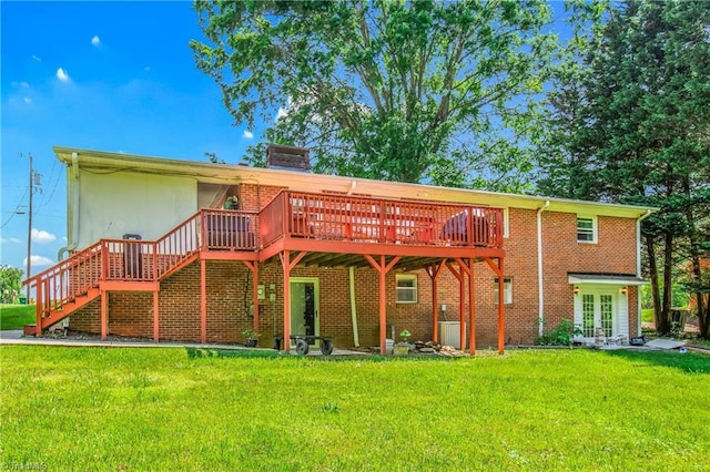 rear view of property featuring a yard, a deck, french doors, brick siding, and stairway